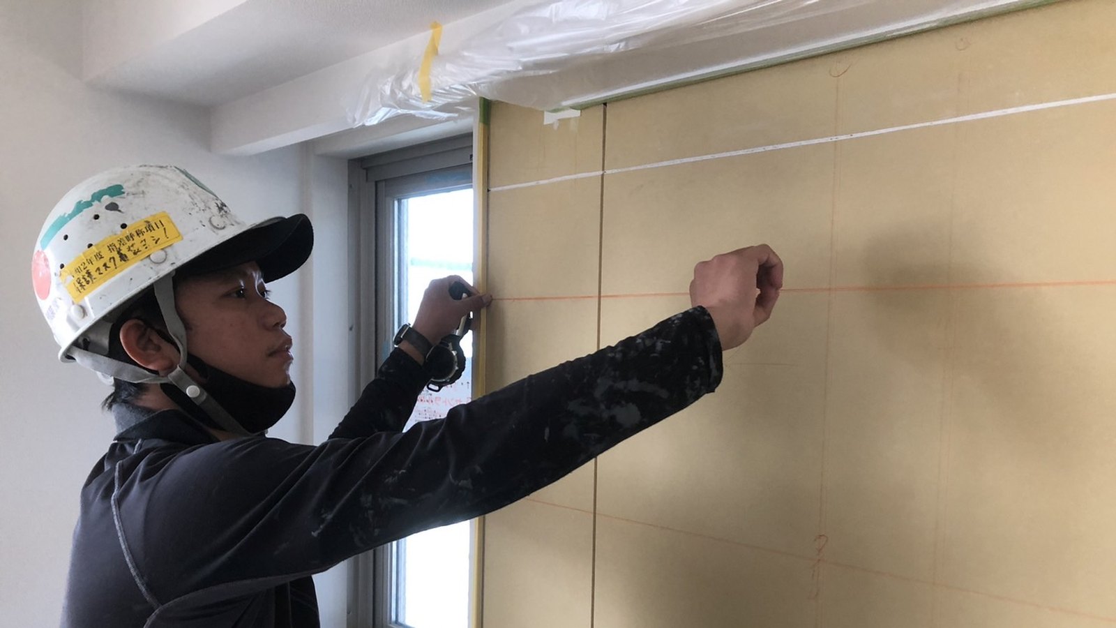 建設現場で墨出しをする外国人材